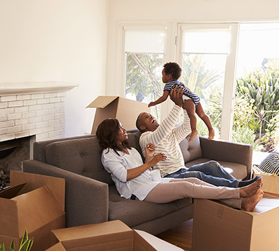 Parents take a break on a couch with their toddler on moving day